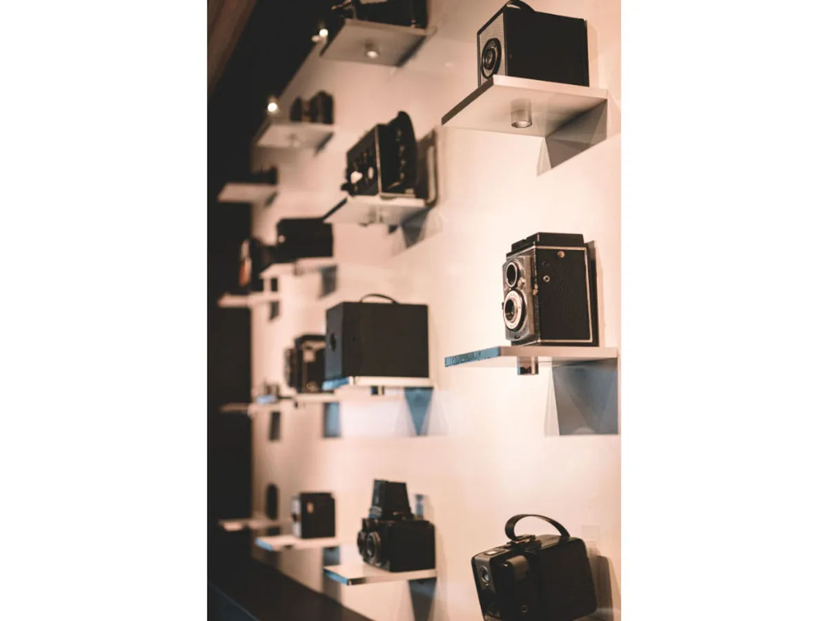 A nostalgic display of vintage cameras on shelves, highlighting the hotel's focus on photography and creative heritage. The warm lighting and arrangement invite guests to explore the history and artistry behind the collection.