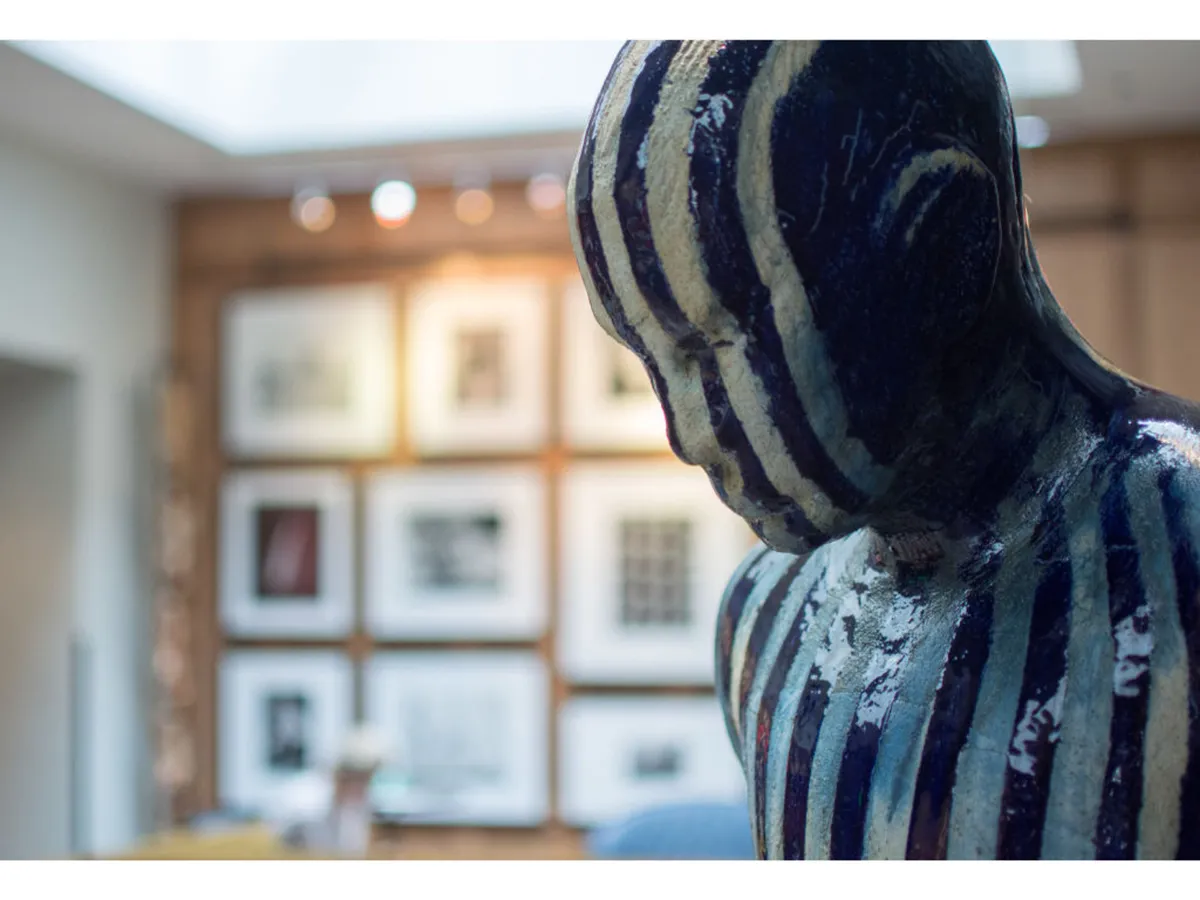 An art-filled interior featuring a striking abstract sculpture and a gallery wall lined with framed artwork, encouraging contemplation and artistic discovery within the hotel.